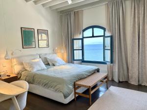 a bedroom with a bed and a large window at Patmos Cliff House in Patmos