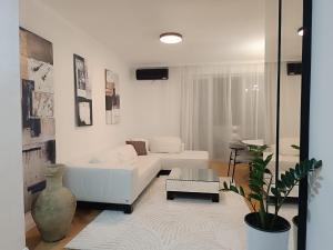 a living room with a white couch and a table at White Lounge Haustor in Podgorica
