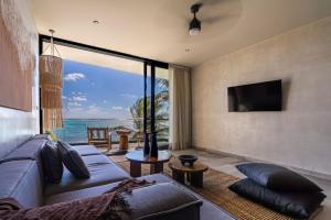 a living room with a couch and a view of the ocean at Luxury Beachfront 4BR PH in Bahia Soliman in Balcheil