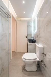 a white bathroom with a toilet and a shower at Dimasti Apartment in Rhodes Town +25 photos