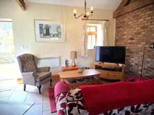 a living room with a couch and a tv at Filey Holiday Cottages in Filey