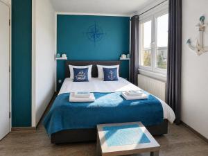 ein Schlafzimmer mit einem großen Bett und blauen Wänden in der Unterkunft Elbhotel Dresden by AURUM in Dresden