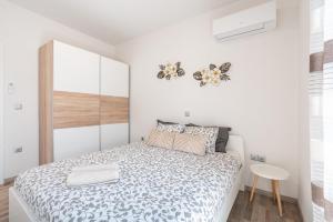 a small white bedroom with a bed and a table at Dimasti Apartment in Rhodes Town