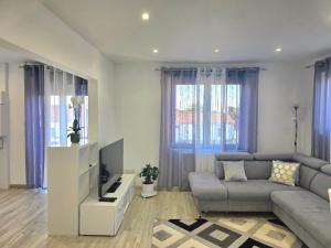 a living room with a couch and a tv at DIAG Appartement 3 Chambres in Commequiers