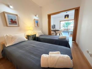 two beds in a room with a table and a chair at Casa Joaninha in Olhão +19 photos