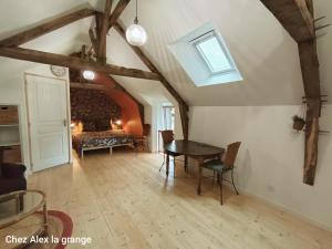 a bedroom with a table and a bed in a room at Chez Alex, La Grange in Saint-Brieuc-des-Iffs