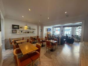a restaurant with tables and people sitting at tables at Americana Hotel in London