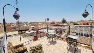 a patio with tables and chairs on a balcony at Riad Layla Rouge in Marrakesh