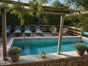 a swimming pool with a pergola and chairs next to it at Salvacintoggio -Votre Villa avec Piscine Privée- in Porto-Vecchio