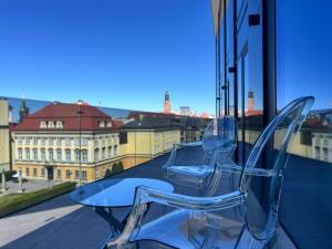 two clear chairs sitting on top of a glass table at Piano Property Rental Wrocław in Wrocław