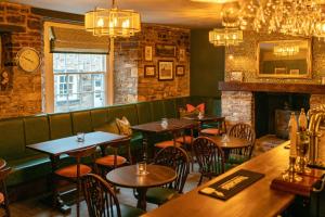 a restaurant with tables and chairs and a fireplace at The Rising Sun - Pensford in Pensford