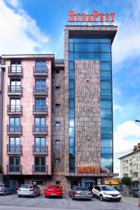 a building with cars parked in front of it at Budapest Hotel - Free Parking in Sofia