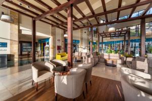 a lobby with chairs and tables in a building at Occidental Jandía Mar - All Inclusive in Morro del Jable