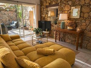 a living room with a couch and a tv at Salvacintoggio -Votre Villa avec Piscine Privée- in Porto-Vecchio