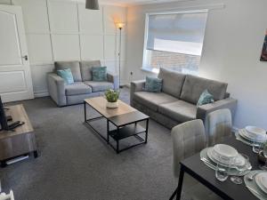a living room with a couch and a table at Chapelhall Contractor Stay in Chapelhall