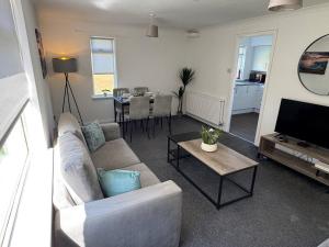 a living room with a couch and a table at Chapelhall Contractor Stay in Chapelhall
