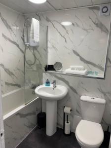 a bathroom with a white toilet and a sink at Chapelhall Contractor Stay in Chapelhall