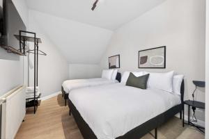 two beds in a bedroom with white walls at Sanctuary Hotel - En Suite Rooms in Aberdeen