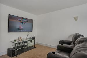 a living room with a couch and a flat screen tv at Heron Landing in Corolla