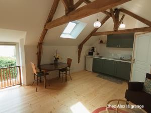 a kitchen and dining room with a table in a room at Chez Alex, La Grange in Saint-Brieuc-des-Iffs +3 photos