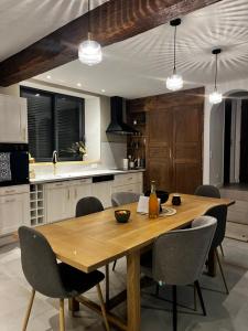 a kitchen with a wooden dining table and chairs at Blanche maison calme in Neuville-sur-Vanne