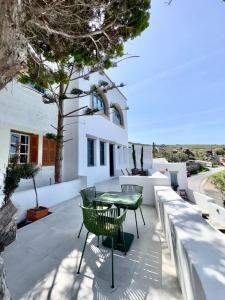 a patio with a table and chairs in front of a building at Patmos Cliff House in Patmos