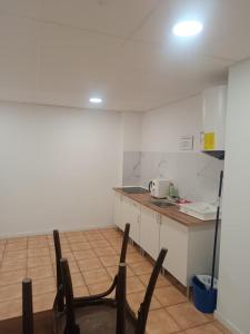 a kitchen with a counter and chairs in a room at Nest Room in Alicante