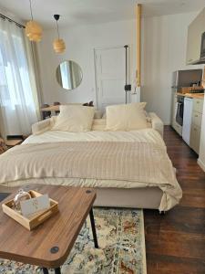 a bedroom with a large bed and a wooden table at La Tour d'Harfleur 1 in Caudebec-en-Caux