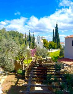 a stone wall in a garden with trees and buildings at Castelli Retreat in Spetses