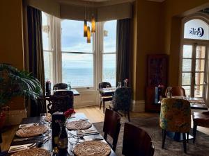 ein Esszimmer mit Tischen und Stühlen und einem großen Fenster in der Unterkunft Weston Hotel in Scarborough
