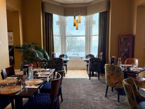 ein Esszimmer mit Tischen und Stühlen und einem großen Fenster in der Unterkunft Weston Hotel in Scarborough