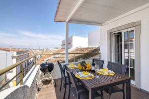 a dining table on a balcony with a view at Flor de Sol House in Tavira +17 photos
