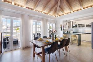 a kitchen and dining room with a wooden table and chairs at Flor de Sol House in Tavira