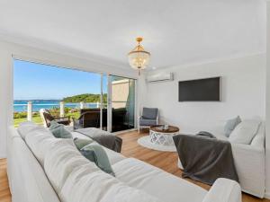 a living room with a white couch and a tv at Elysian Shores in Long Beach