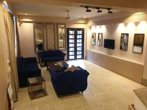 a living room with two blue chairs and a table at Shelton Hotel Johar Town Lahore in Lahore