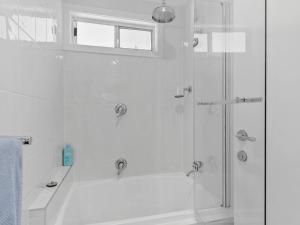 a white bathroom with a shower and a tub at Elysian Shores in Long Beach +44 photos