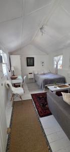 a white bedroom with a bed and a couch at Oh so Heavenly in Cape Town