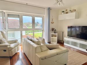 a living room with a white couch and a tv at Apartamento La Bruma 30807 in Somo