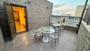 a patio with tables and chairs on a balcony at Jawheret S Hotel Suite in Amman