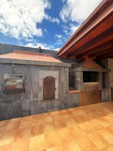 a large outdoor kitchen with an oven and a pizza at Villa en el Time con piscina in Puerto del Rosario