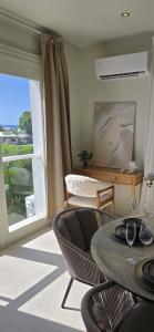 a living room with a table and chairs and a window at Mullins Townhouse in Saint Peter