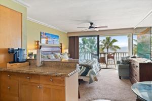 a bedroom with a bed and a view of the ocean at Maui Beachfront Haven 433 in Lahaina