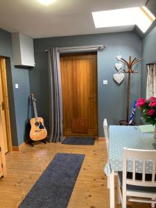 a room with a table and a guitar on the wall at Jakels Rest in Lairg