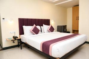 a bedroom with a large bed with pink pillows at Hotel Konark Inn in Indore +22 photos