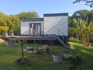 a tiny house in a yard with plants at Independent studio in Pont-lʼAbbé