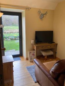 a living room with a couch and a television at Jakels Rest in Lairg
