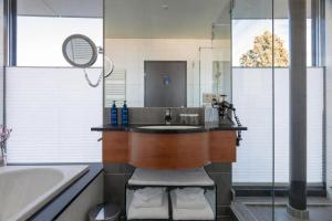 a bathroom with a sink and a tub and a mirror at Radisson Blu Hotel, St. Gallen in St. Gallen