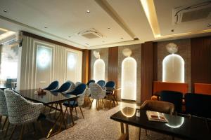 a waiting room with chairs and tables in a building at Hotel Madhuram Shivpuri MP in Shivpurī