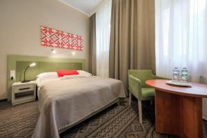a hotel room with a bed and a table at Hotel *** NAT Krynica Zdrój in Krynica Zdrój