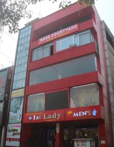 a red building with a first lady sign on it at Kasa Courtyard Hotel in Begusarai